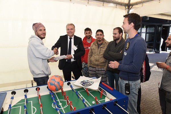 FC Den Bosch-directeur Edward van Wonderen overhandigt toegangskaarten aan de asielzoekers (foto: Henk van Esch)
